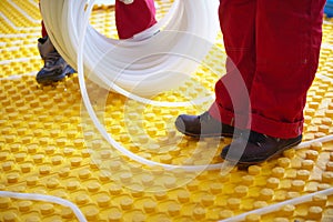 Workers installing underfloor heating system