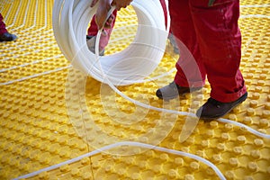 Workers installing underfloor heating system