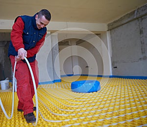 Workers installing underfloor heating system