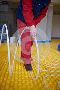 Workers installing underfloor heating system