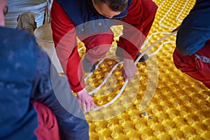 Workers installing underfloor heating system