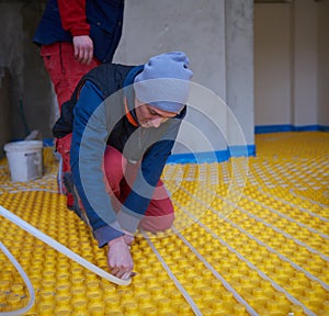 Workers installing underfloor heating system