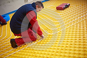 Workers installing underfloor heating system