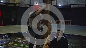 Workers installing wooden beam for the performance. Media. Creative stage decoration details.