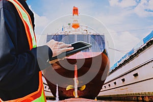 Workers with Ipad in hand holding on floating dock yard Stern propeller, rudder and shafting port controller,