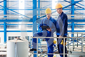 Workers in large metal workshop checking work