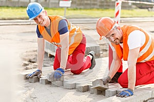Workers laying cobblestones photo