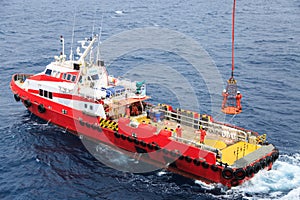 Workers are lifted by the crane to the offshore platform, Transfer crews by personal basket from the platform to crews boat