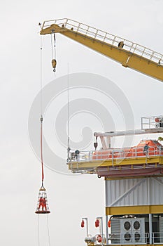 Workers are lifted by the crane to the platform