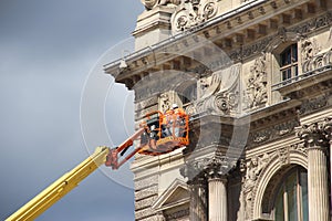Workers maintain Louvre Museum facade