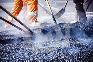 Workers making asphalt with shovels