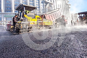 Workers making asphalt with shovels at road constructio