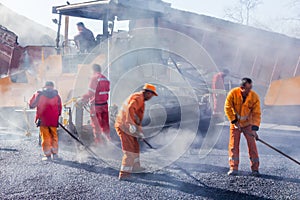 Lavoratori creazione asfalto pale sul strade 