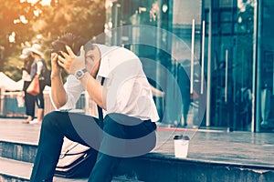 Workers man sitting headache in front of the company about his w