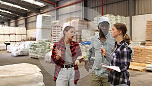 Workers and manager discussing completed work in a large warehouse