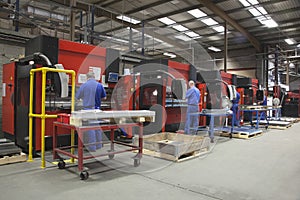 Workers At Manufacture Workshop Operating Machines