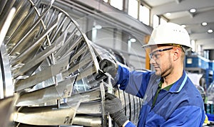 Workers manufacturing steam turbines in an industrial factory