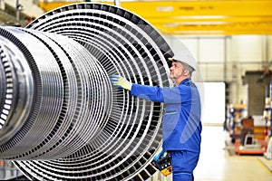 Workers manufacturing steam turbines in an industrial factory