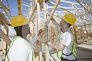 Workers Measuring Level Of Wooden Beam