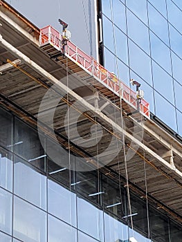 Workers on mobile platform building skyscraper photo