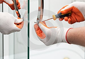 Workers are mounting door handles of the shower enclosure