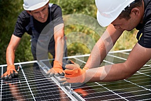 Workers mounting photovoltaic solar panel system