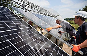 Workers mounting photovoltaic solar panel system