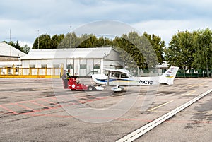 Workers moving Cessna 172 SP airplane to hangar.