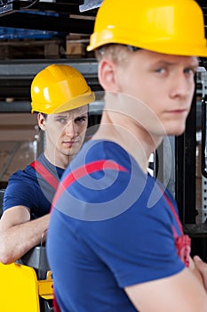 Workers next to forklift
