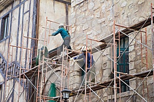 Workers with no protection belt fixed on scaffold at construction site photo