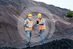 Workers in open-cast mining operation pit