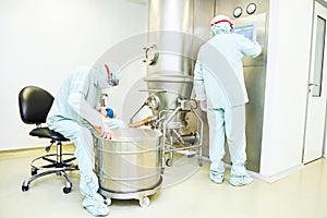 Workers operating pharma fluid bed system