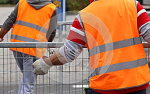 workers with orange high-visibility vest while moving the iron f