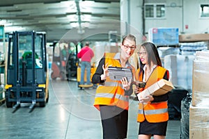 Workers with package in warehouse of forwarding