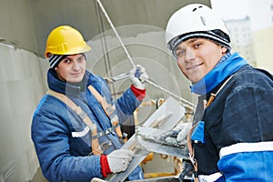 Workers at plastering facade work