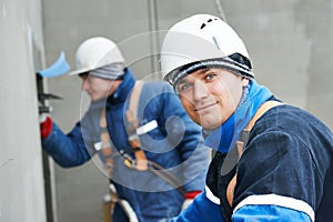 Workers at plastering facade work