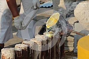 Workers are pouring gold into the mold to create a Buddha statue.