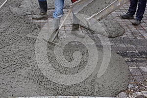 Workers pouring wet concrete using concrete bucket. Industrial construction