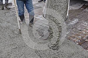 Workers pouring wet concrete using concrete bucket. Industrial construction