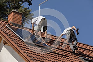 Workers prepare the roof for the installation of solar panels. Two men on the roof of a family house. Photovoltaic installation