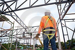 Workers prepare to go up with Fall arrestor device for worker with hooks for safety body harness on onstruction site