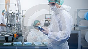 Workers producing surgical mask in modern factory, Covid-19 protection and medical concept