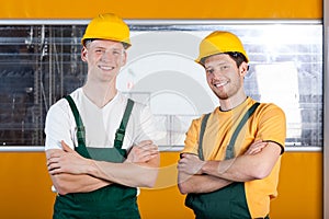 Workers in protective workwear standing with arms crossed