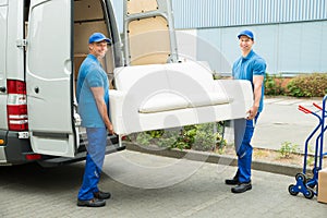 Workers Putting Furniture And Boxes In Truck photo