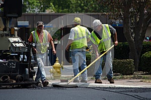 Workers raking asphalt