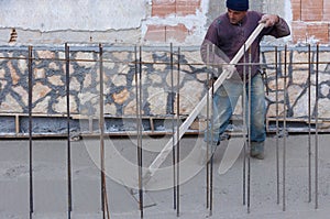 Workers with rake leveled the concrete