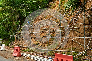 Workers reinforce the mountainside to prevent landslides on the road