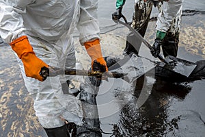 Workers remove crude oil from a beach, Crude oil on oil spill