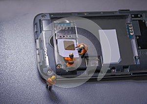 Workers remove and insert sim card into mobile phone