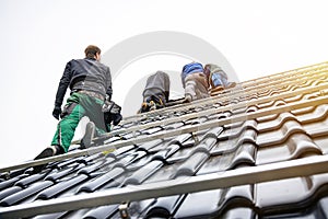 Workers an a roof of a house installing solar panels